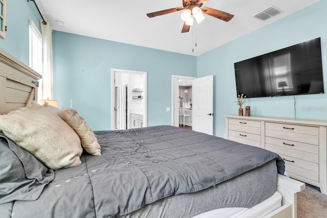 carpeted bedroom with ceiling fan and ensuite bathroom