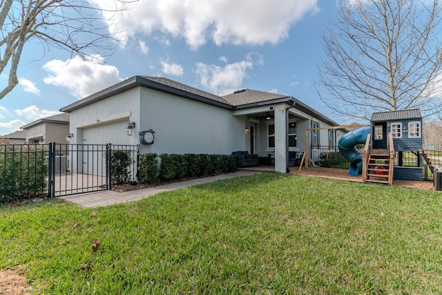 exterior space with a garage, a playground, and a front lawn