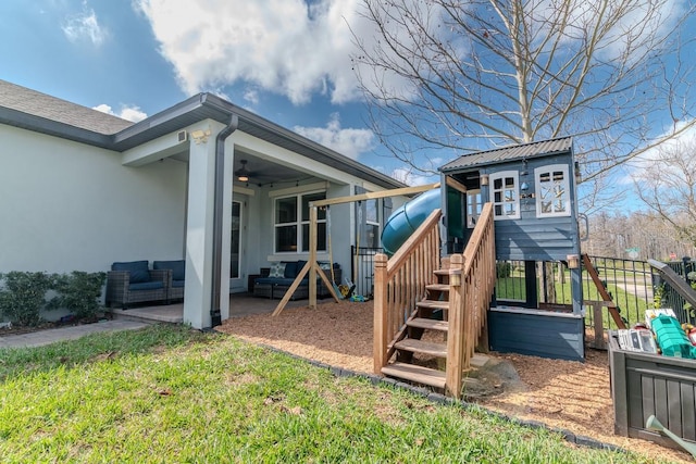 view of playground featuring an outdoor living space, ceiling fan, and a lawn