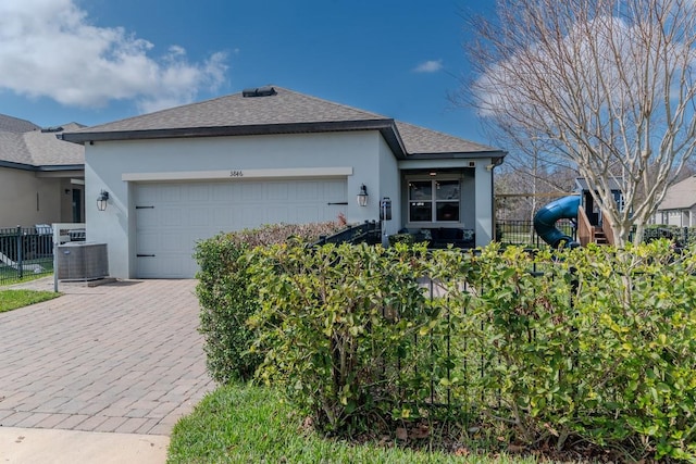 ranch-style house with a garage, a playground, and central air condition unit