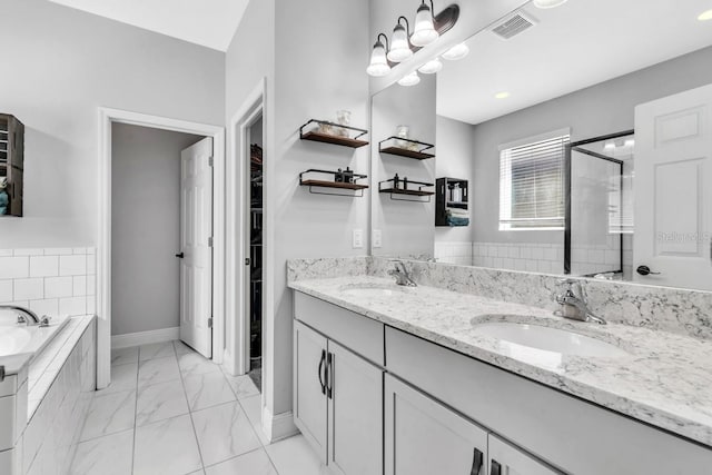 bathroom featuring tiled tub and vanity