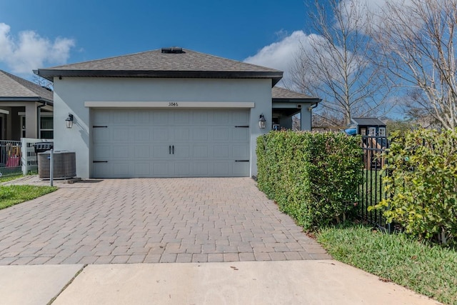 view of front facade featuring a garage and central AC unit