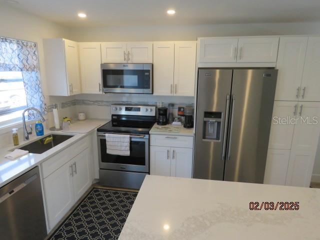 kitchen featuring sink, white cabinets, and appliances with stainless steel finishes