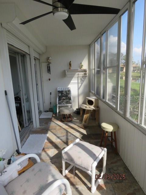 sunroom featuring ceiling fan and plenty of natural light