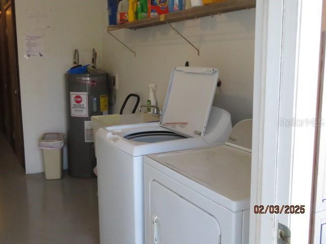 washroom with water heater and washer and clothes dryer