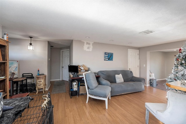 living room featuring a textured ceiling and light wood-type flooring