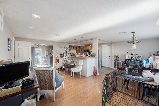 living room featuring ceiling fan and light wood-type flooring