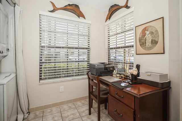 office with stacked washer / drying machine, baseboards, and light tile patterned floors