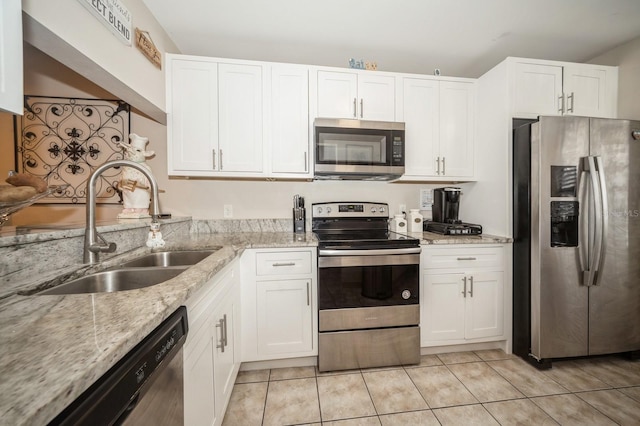 kitchen with white cabinets, light tile patterned floors, stainless steel appliances, and a sink