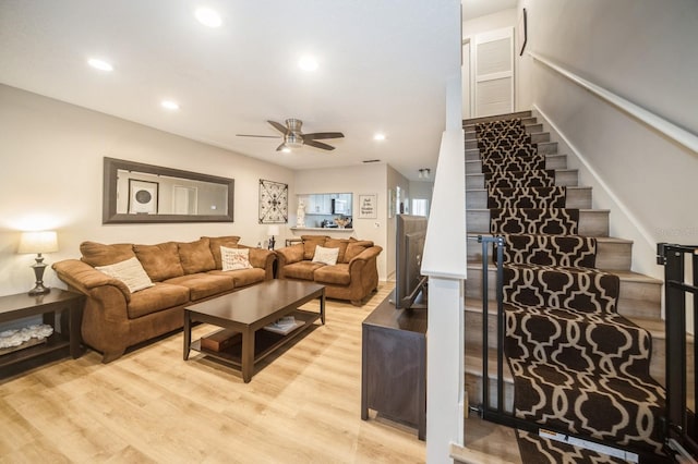 living room with light wood-style floors, ceiling fan, stairway, and recessed lighting