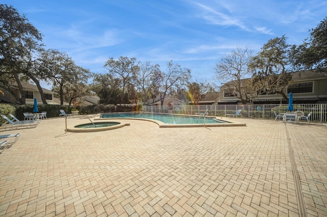 pool featuring a community hot tub, a patio area, and fence