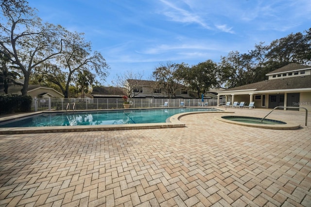 community pool featuring a community hot tub, fence, and a patio