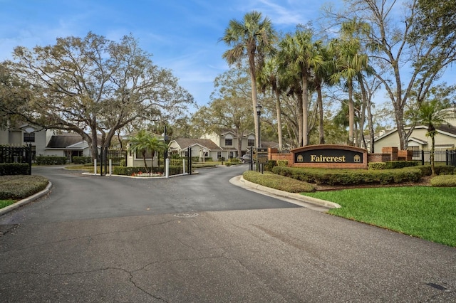 view of street with a residential view, curbs, and a gated entry