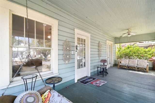 wooden terrace with ceiling fan and covered porch