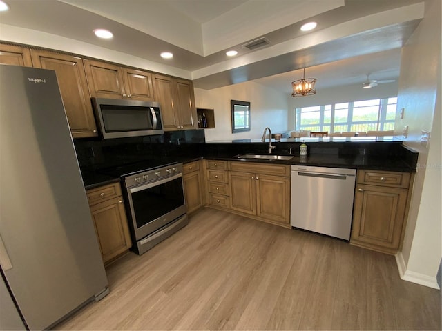 6315 Shoreline Dr Unit 3204, Seminole, FL 33708 - kitchen featuring stainless steel appliances, light wood finished floors, brown cabinetry, and a sink