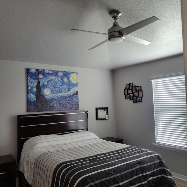 bedroom with ceiling fan and a textured ceiling