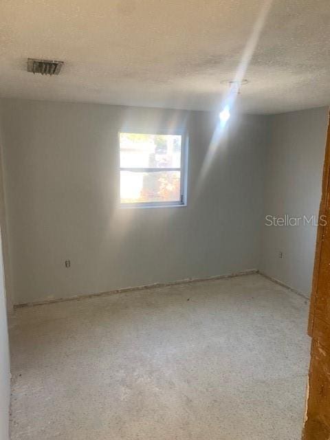 unfurnished room featuring a textured ceiling