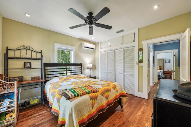 bedroom with ceiling fan, dark wood-type flooring, a wall unit AC, and a closet