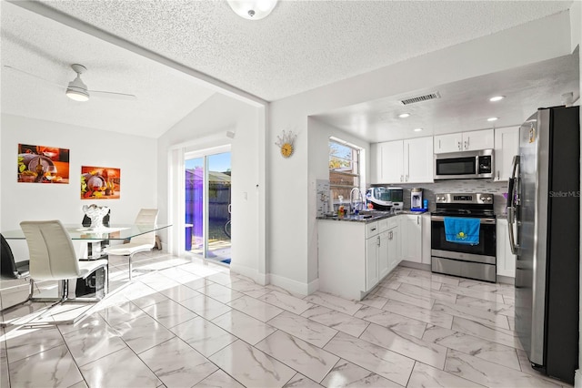 kitchen featuring sink, a textured ceiling, white cabinets, and stainless steel appliances