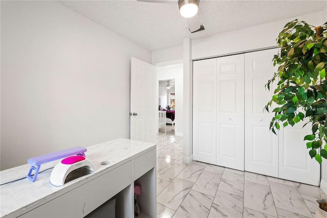 home office featuring ceiling fan and a textured ceiling