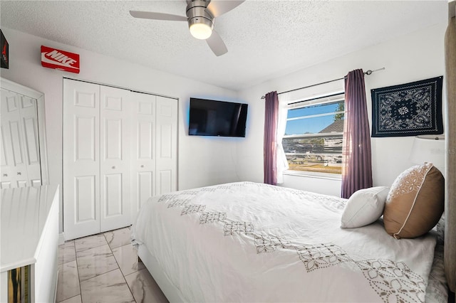 bedroom featuring a closet, ceiling fan, and a textured ceiling