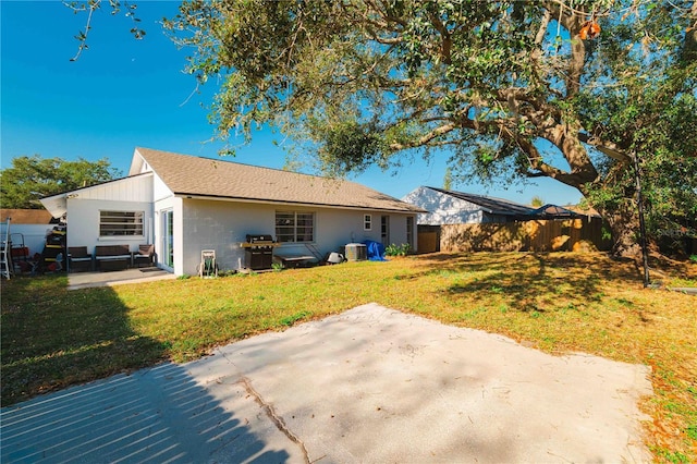 rear view of house featuring central air condition unit, a patio area, and a yard