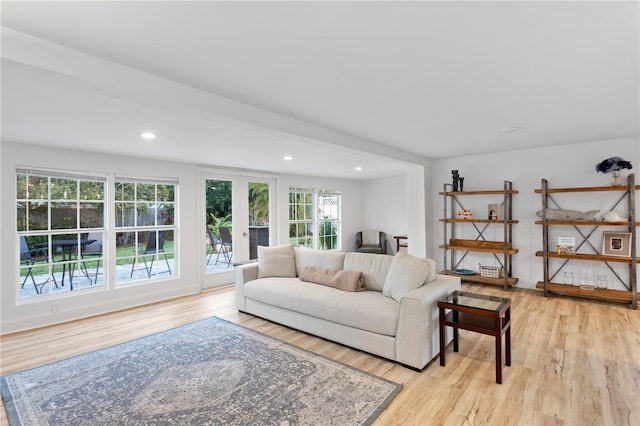 living room featuring baseboards, french doors, light wood-type flooring, and recessed lighting