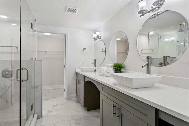 bathroom with marble finish floor, visible vents, a sink, and a stall shower