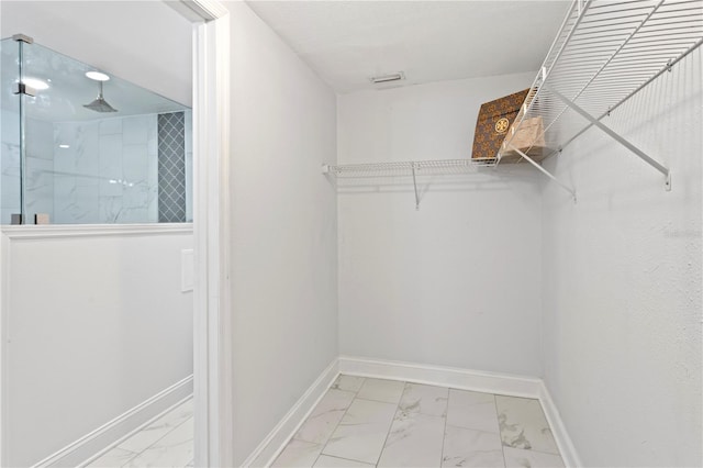 walk in closet with marble finish floor