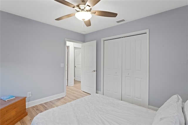 bedroom featuring a closet, baseboards, visible vents, and light wood finished floors