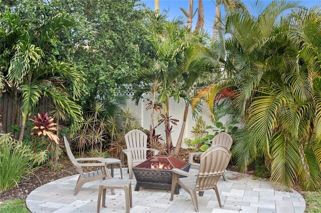 view of patio featuring an outdoor fire pit and fence