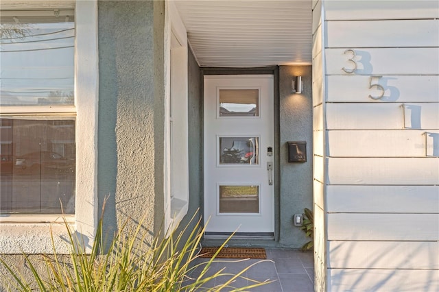 entrance to property featuring stucco siding