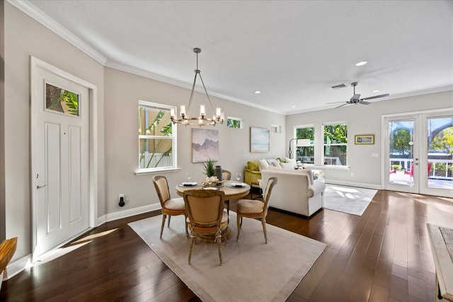 dining area with crown molding, dark hardwood / wood-style floors, ceiling fan with notable chandelier, and french doors