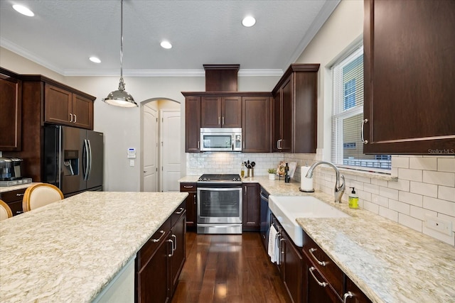 kitchen with sink, dark hardwood / wood-style floors, pendant lighting, stainless steel appliances, and backsplash