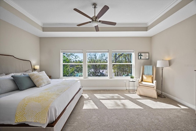 bedroom with ornamental molding, light colored carpet, ceiling fan, and a tray ceiling