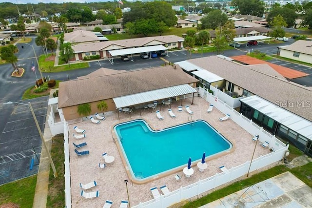 community pool featuring a residential view, fence, and a patio