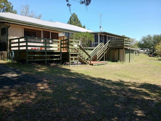 back of house with a wooden deck and a sunroom