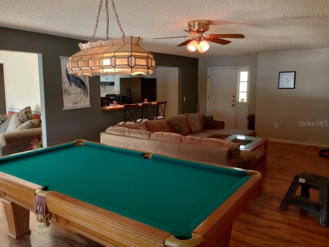 game room with ceiling fan, hardwood / wood-style flooring, pool table, and a textured ceiling