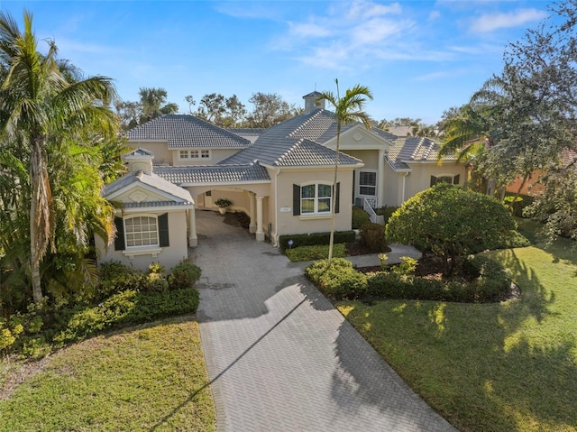 mediterranean / spanish-style home with a carport and a front lawn