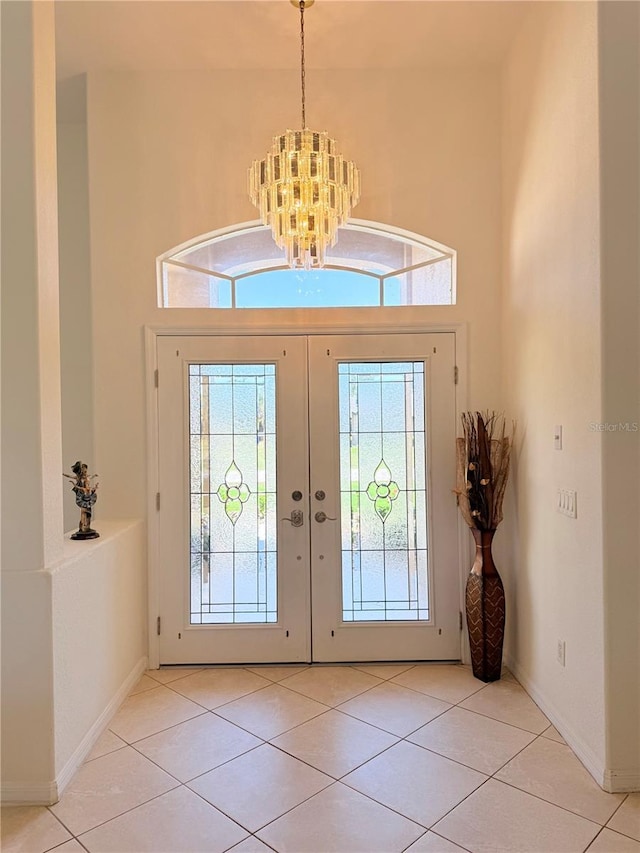 entrance foyer with a high ceiling, light tile patterned floors, and an inviting chandelier