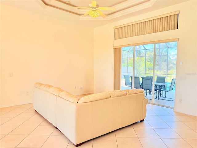 tiled living room featuring ceiling fan, ornamental molding, and a raised ceiling