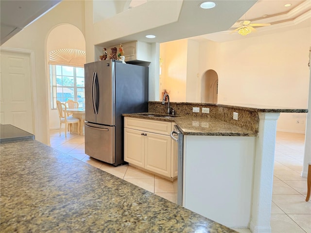 kitchen featuring white cabinetry, sink, dark stone countertops, light tile patterned floors, and stainless steel appliances