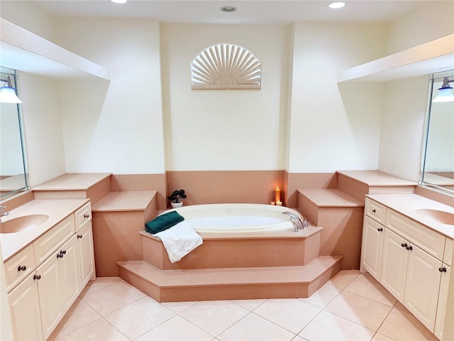 bathroom featuring tile patterned flooring, vanity, and tiled bath