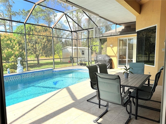 view of swimming pool featuring area for grilling, a lanai, a patio area, and a storage unit