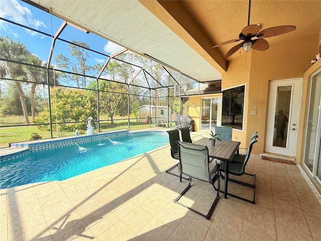 view of swimming pool featuring a lanai, a patio, ceiling fan, and a storage unit