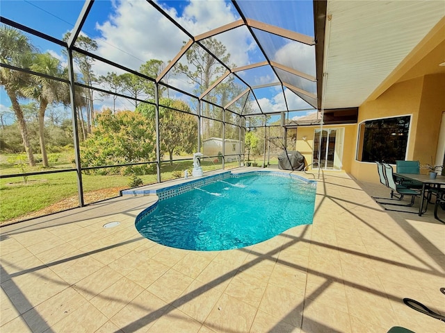 view of swimming pool featuring a patio, a storage unit, and glass enclosure