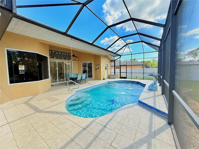 view of pool with a patio, pool water feature, ceiling fan, and glass enclosure