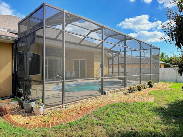 rear view of property featuring a patio, a lanai, and a lawn