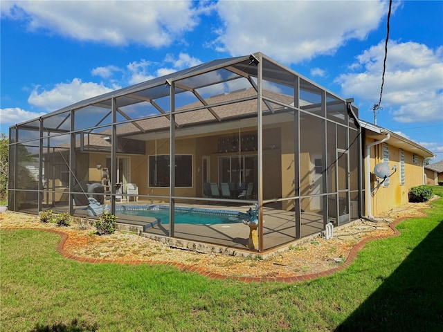 rear view of property with a patio, glass enclosure, and a lawn