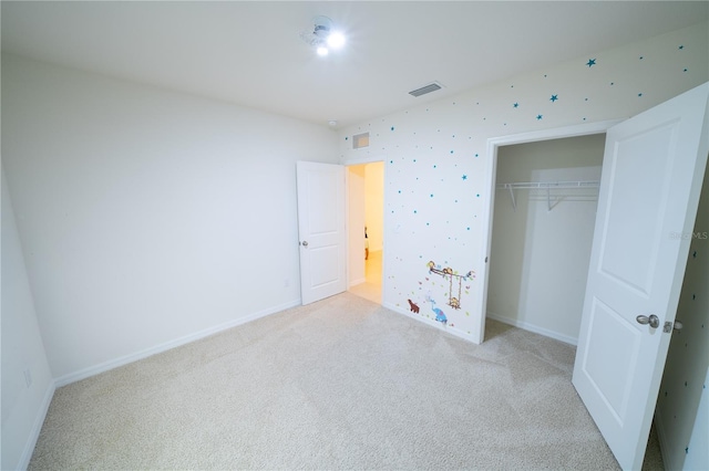 unfurnished bedroom with light carpet and a closet